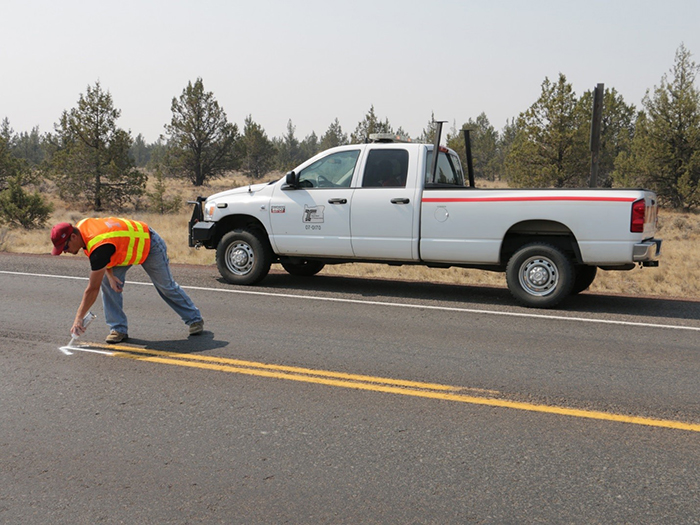 photo of an ODOT crew member marking a location for a striping change