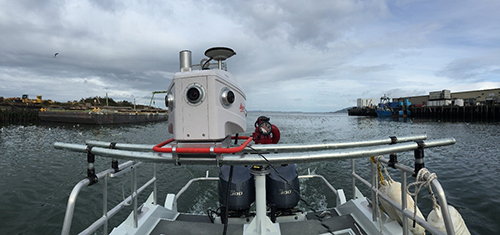 photo of a mobile LiDAR unit mounted on top of a boat in a harbor